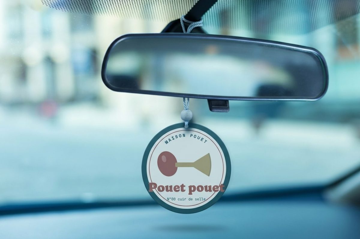 Sent-bon Pouet pouet en forme de plaque émaillée ronde avec un klaxon à poire, suspendu au rétroviseur d'une voiture