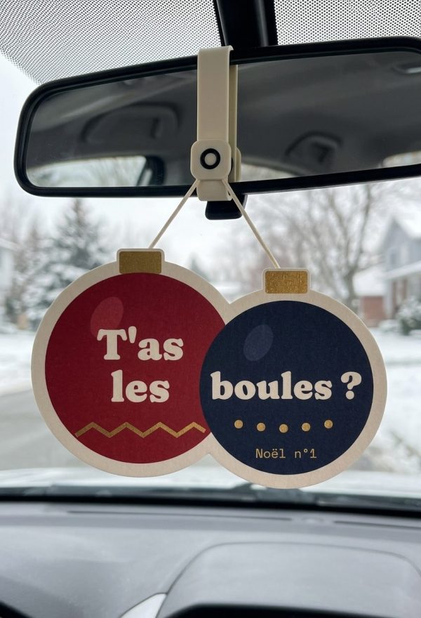 Sent-bon de Noël T'as les boules ?, deux boules de sapin, accroché au rétroviseur devant un paysage enneigé